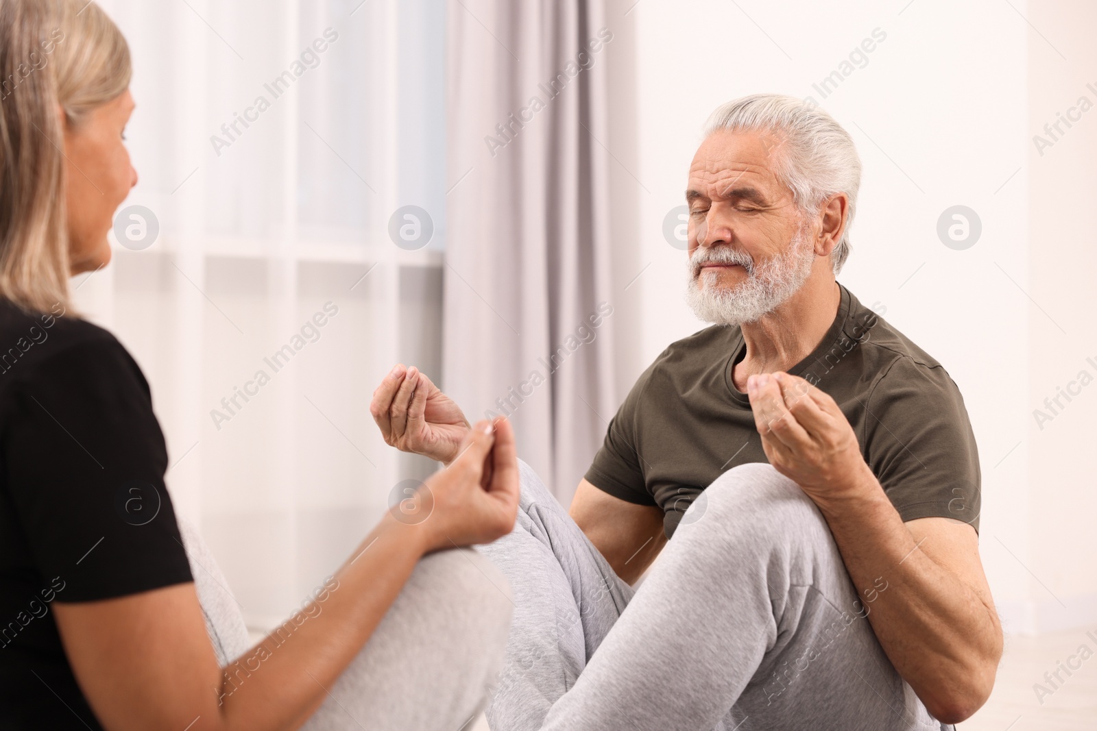 Photo of Senior couple practicing yoga at home. Healthy lifestyle