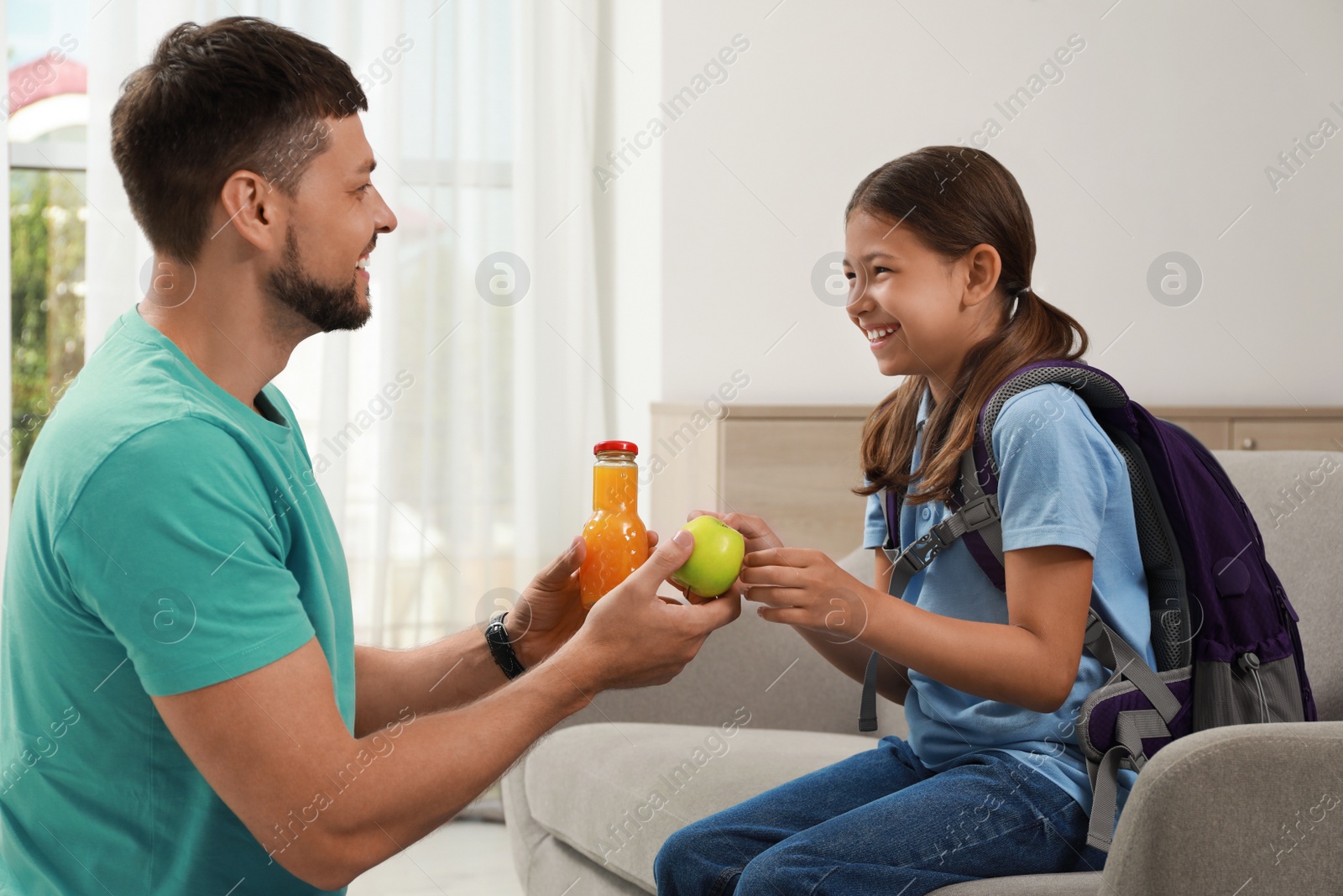 Photo of Father helping his daughter to get ready for school at home