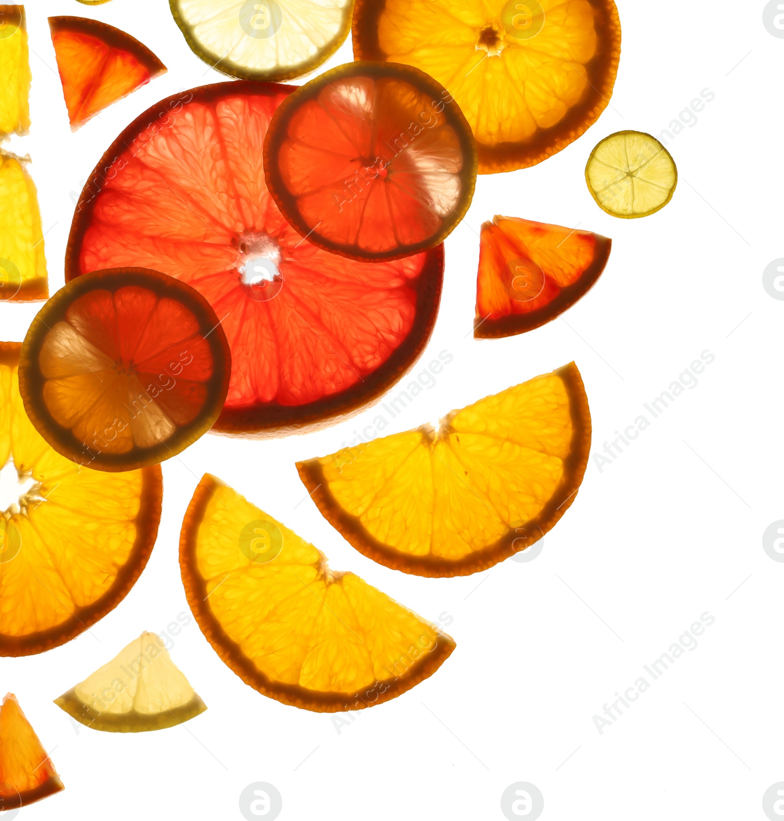 Photo of Illuminated slices of citrus fruits on white background, top view