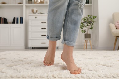 Photo of Woman standing on beige carpet in room, closeup