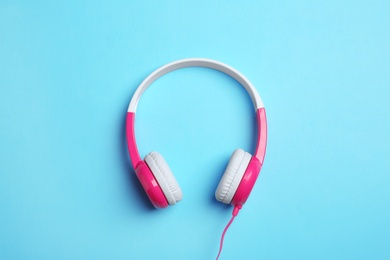 Stylish headphones on color background, top view