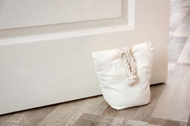 Photo of Stuffed bag holding wooden door at home