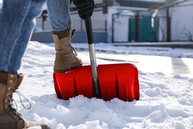 Person shoveling snow outdoors on winter day, closeup