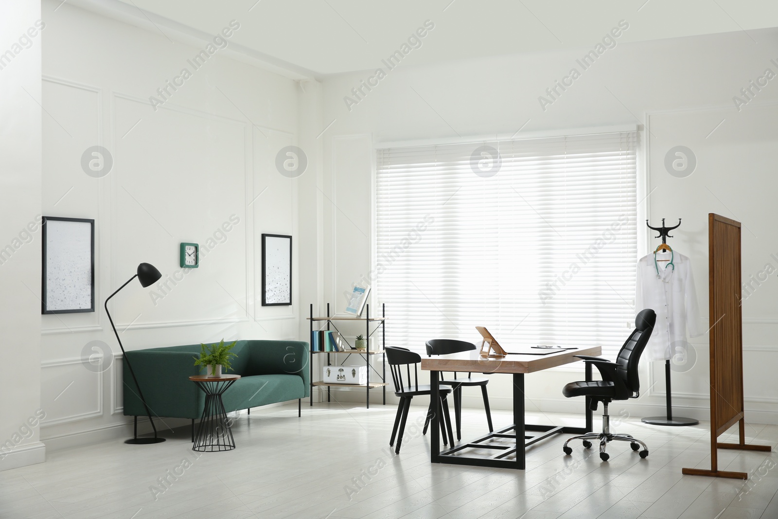 Photo of Modern medical office interior with doctor's workplace and sofa