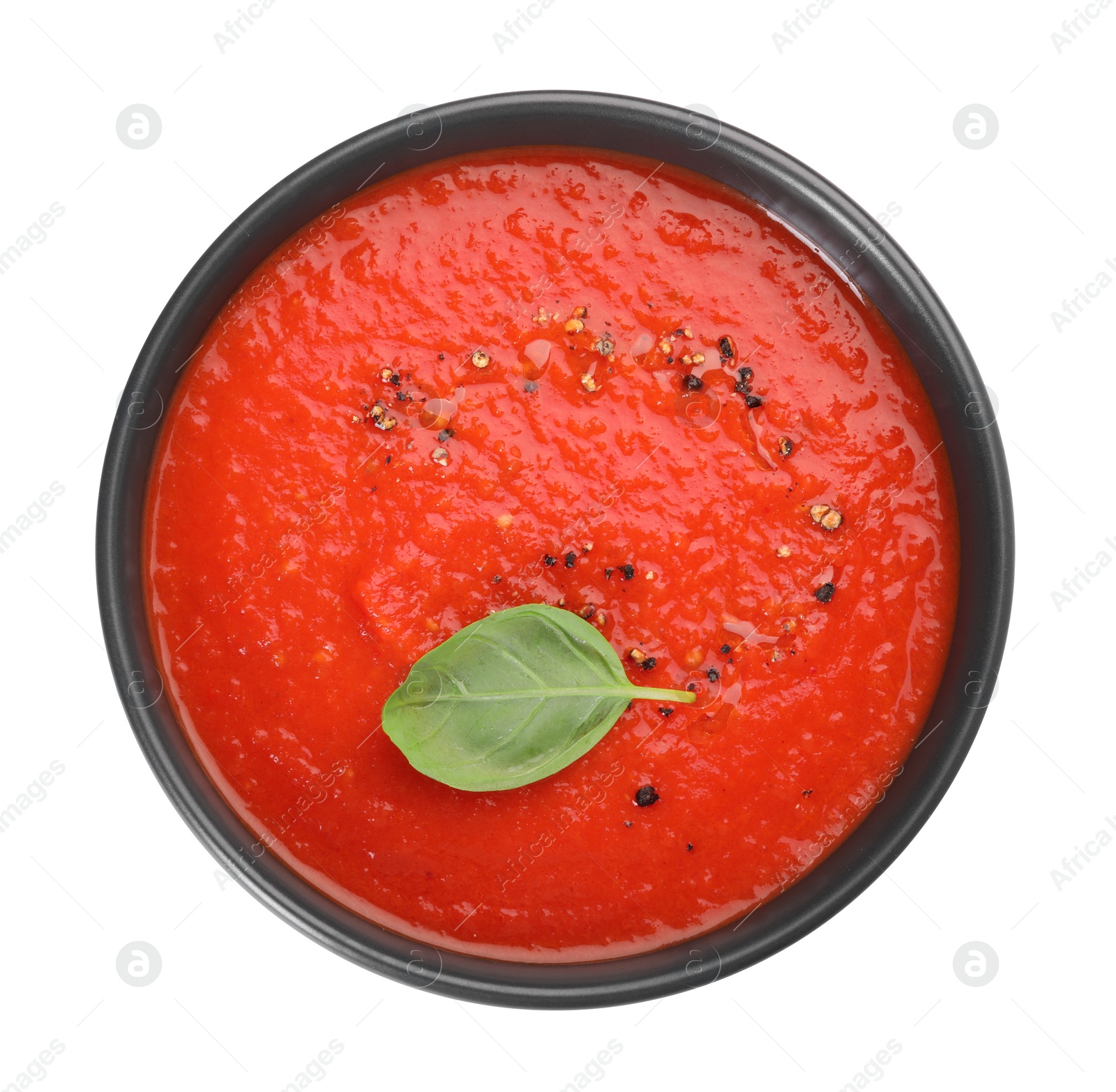 Photo of Delicious tomato cream soup in bowl isolated on white, top view