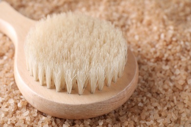 Photo of Salt for spa scrubbing procedure and brush, closeup