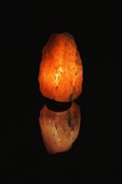 Photo of Himalayan salt lamp on black background