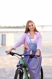 Young woman riding bicycle in city on sunny day