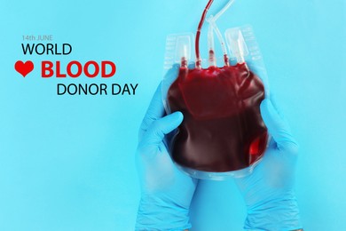 Image of World Donor Day. Doctor in gloves holding blood pack on light blue background, top view 