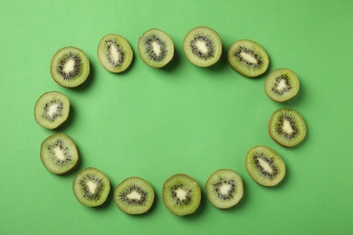 Photo of Frame made of fresh kiwis on green background, top view. Space for text
