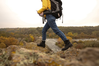 Photo of Woman with backpack on steep cliff, closeup