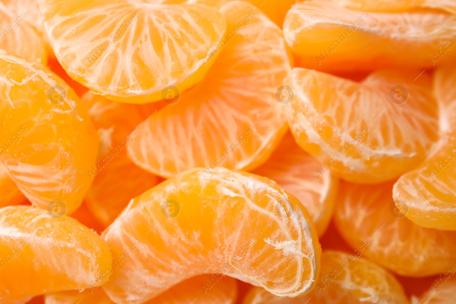 Photo of Fresh juicy tangerine segments as background, top view