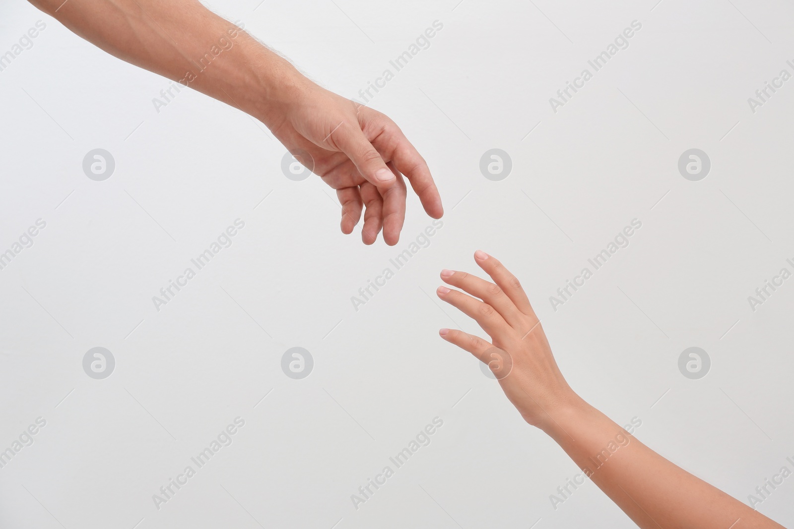 Photo of Man and woman giving each other hands on light background. Concept of support and help