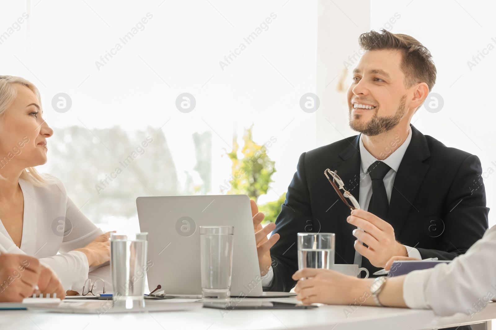 Photo of Group of people discussing ideas at table in office. Consulting service concept