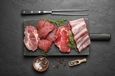 Flat lay composition with fresh meat on black table