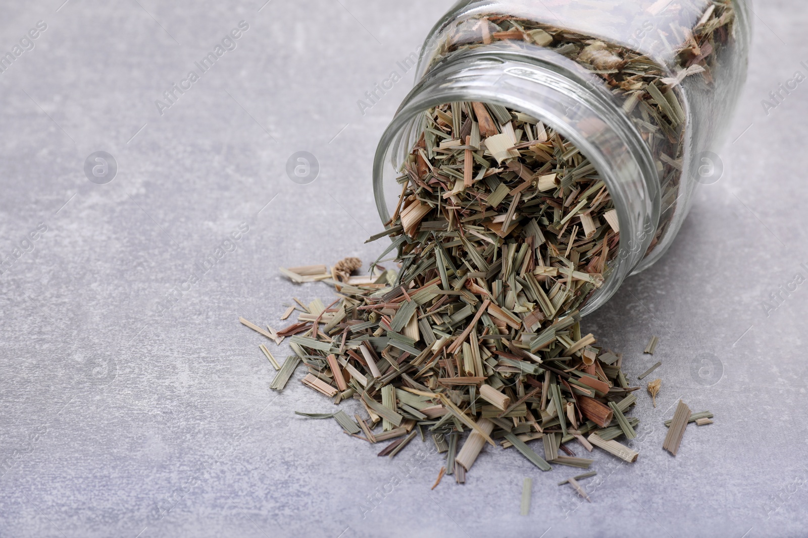 Photo of Jar with aromatic dried lemongrass on light grey table