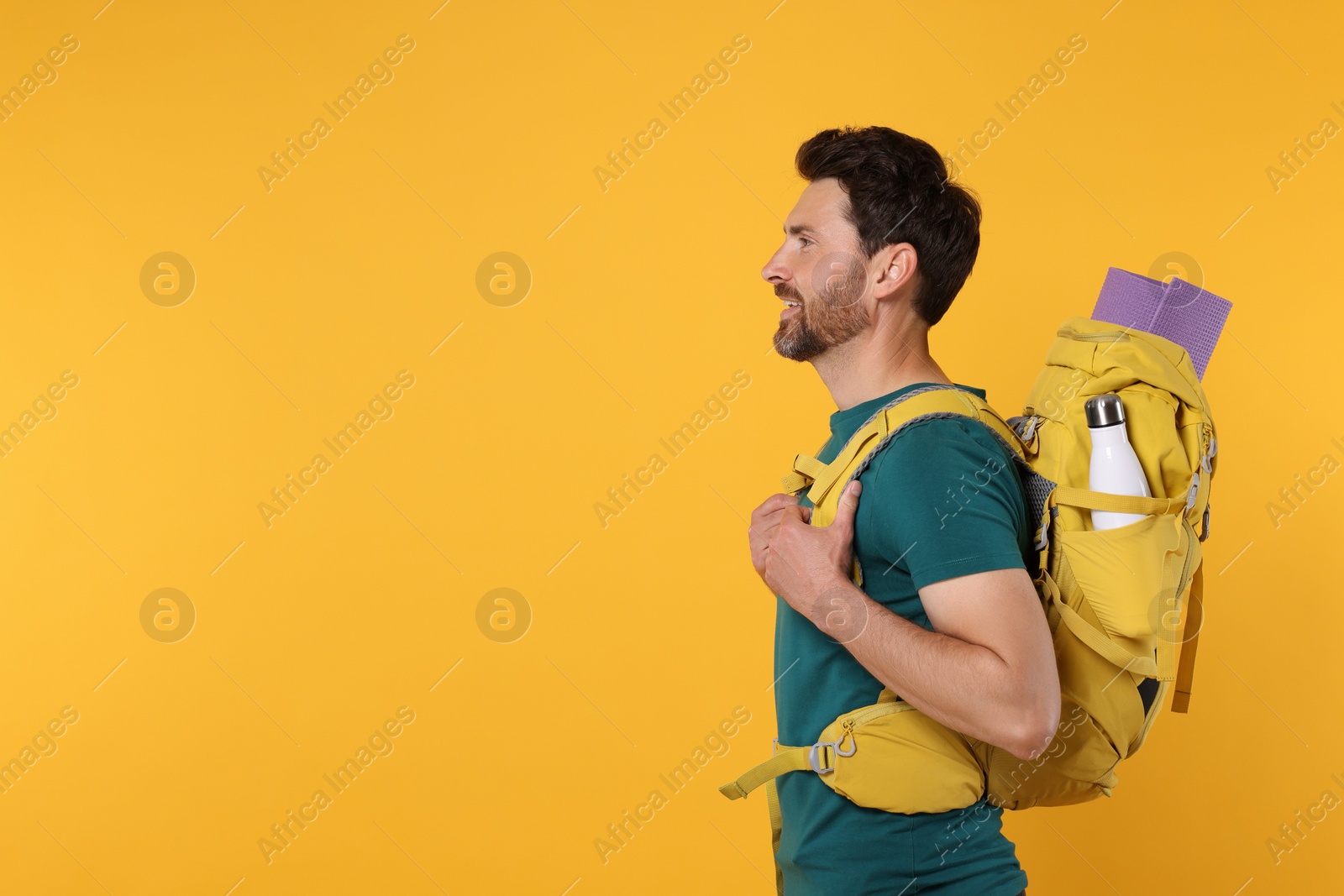 Photo of Man with backpack on orange background, space for text. Active tourism