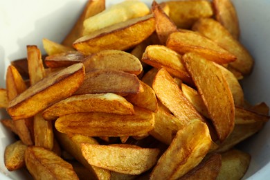 Photo of Metal bowl with delicious fried potato wedges, closeup