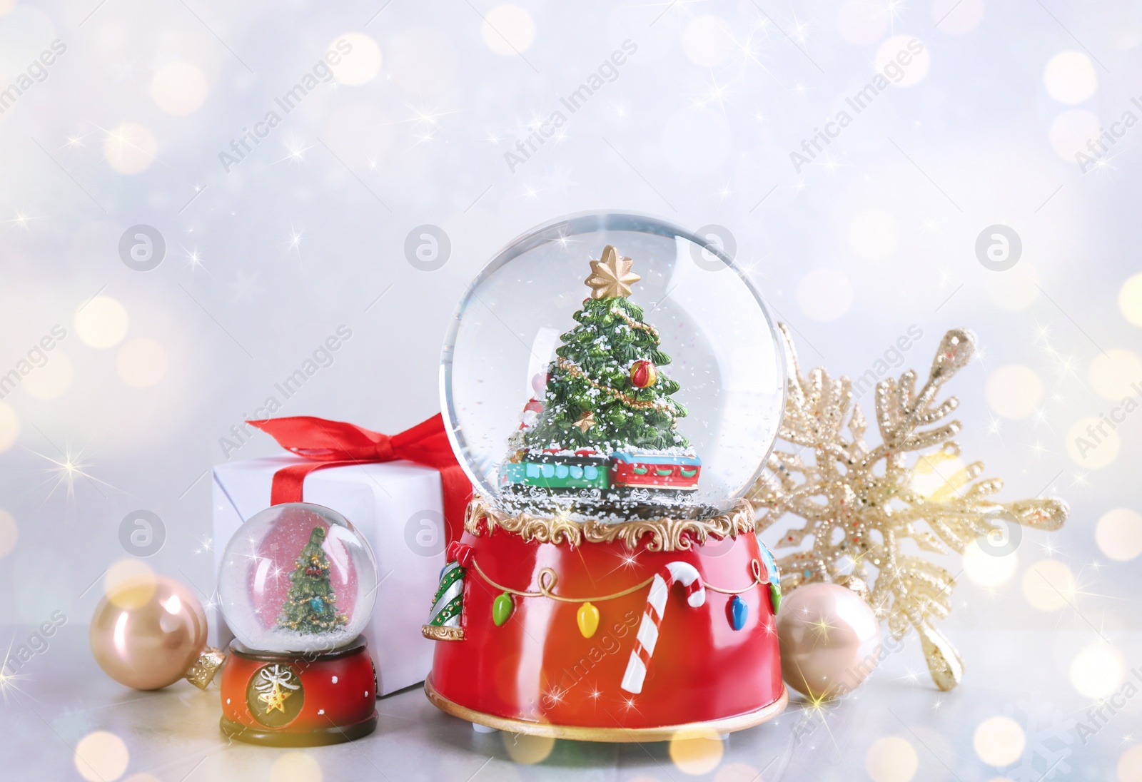 Image of Beautiful snow globes and Christmas decor on light background. Bokeh effect 