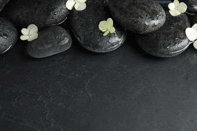 Stones and flowers in water on dark background, space for text. Zen lifestyle