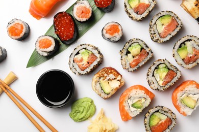 Photo of Set of delicious sushi rolls on white background, flat lay