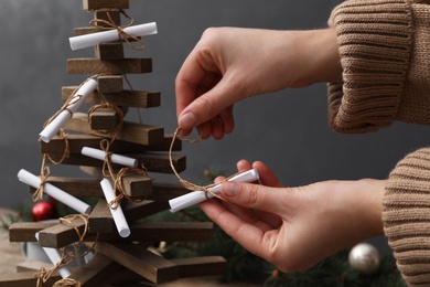 Woman making advent calendar on grey background, closeup