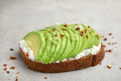 Photo of Crisp rye toast with sliced avocado and cream cheese on table