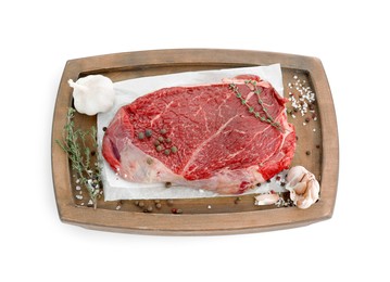 Wooden tray with piece of raw meat, garlic and thyme isolated on white, top view