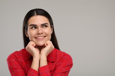 Photo of Young woman with clean teeth smiling on light grey background. Space for text