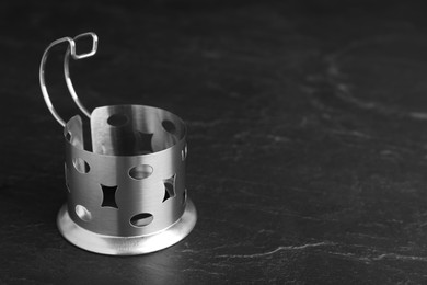 Photo of Traditional tea glass holder on black table, space for text