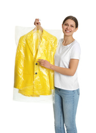 Photo of Young woman holding hanger with jacket in plastic bag on white background. Dry-cleaning service