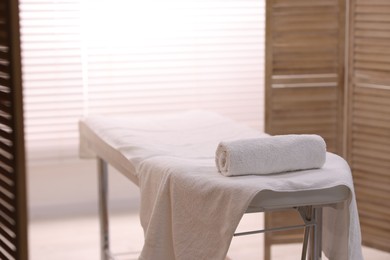 Photo of Rolled towel on massage table in spa center