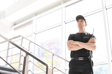 Photo of Male security guard with portable radio transmitter indoors