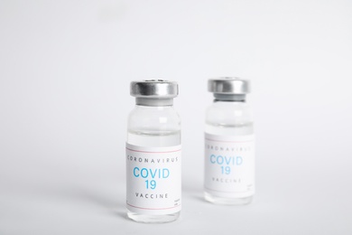 Photo of Vials with coronavirus vaccine on white background