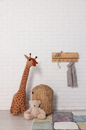 Photo of Beautiful children's room with white brick wall and toys. Interior design