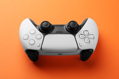 One wireless game controller on orange background