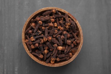 Photo of Aromatic cloves in bowl on grey wooden table, top view