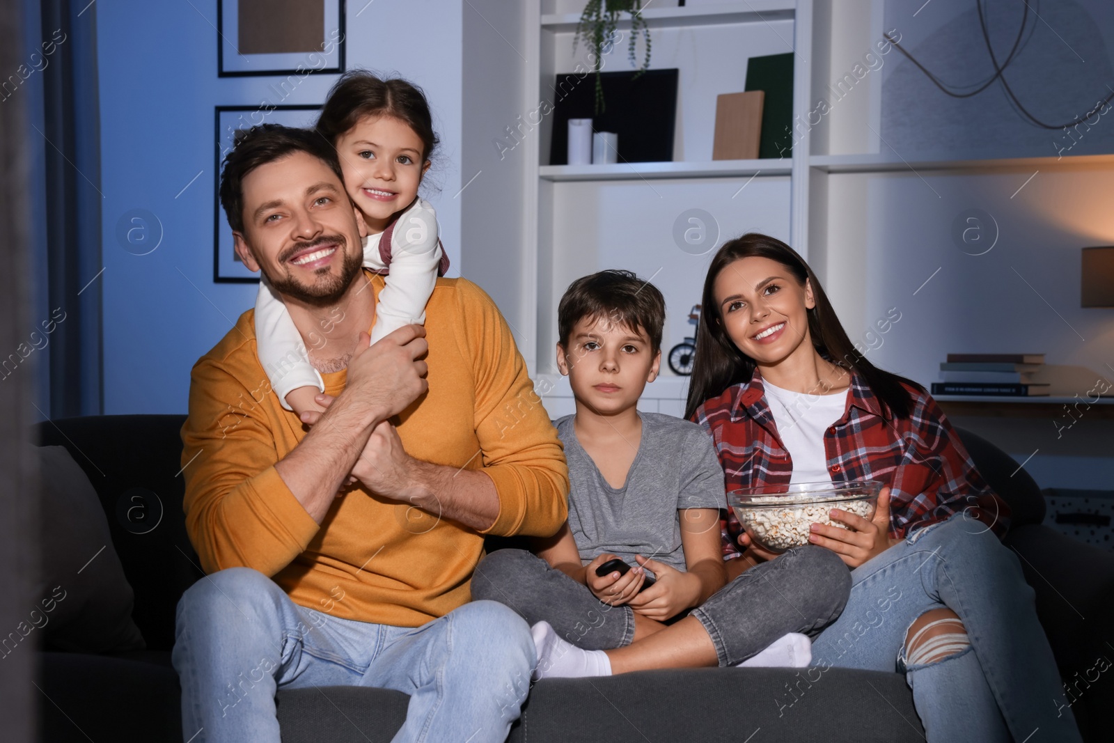 Photo of Family watching TV at home in evening