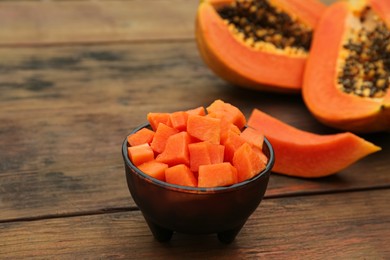 Tasty cut papaya fruits on wooden table, closeup