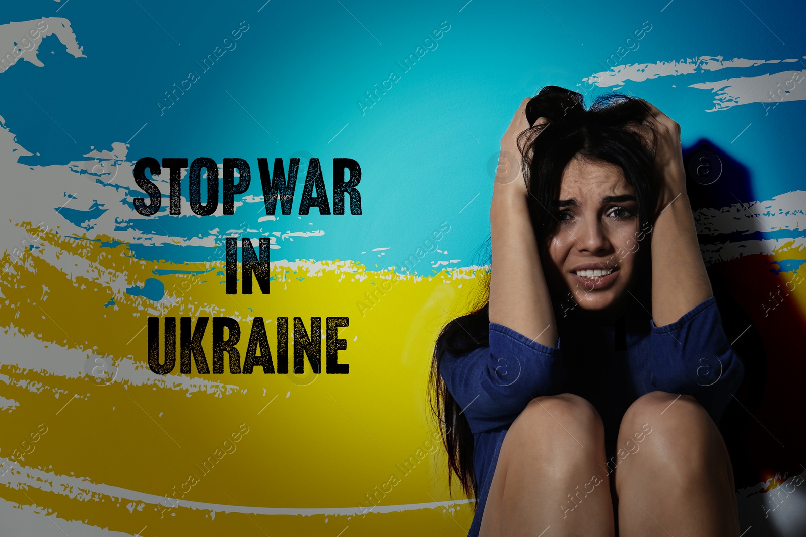 Image of Stop War in Ukraine. Afraid young woman sitting near wall painted in colors of Ukrainian national flag