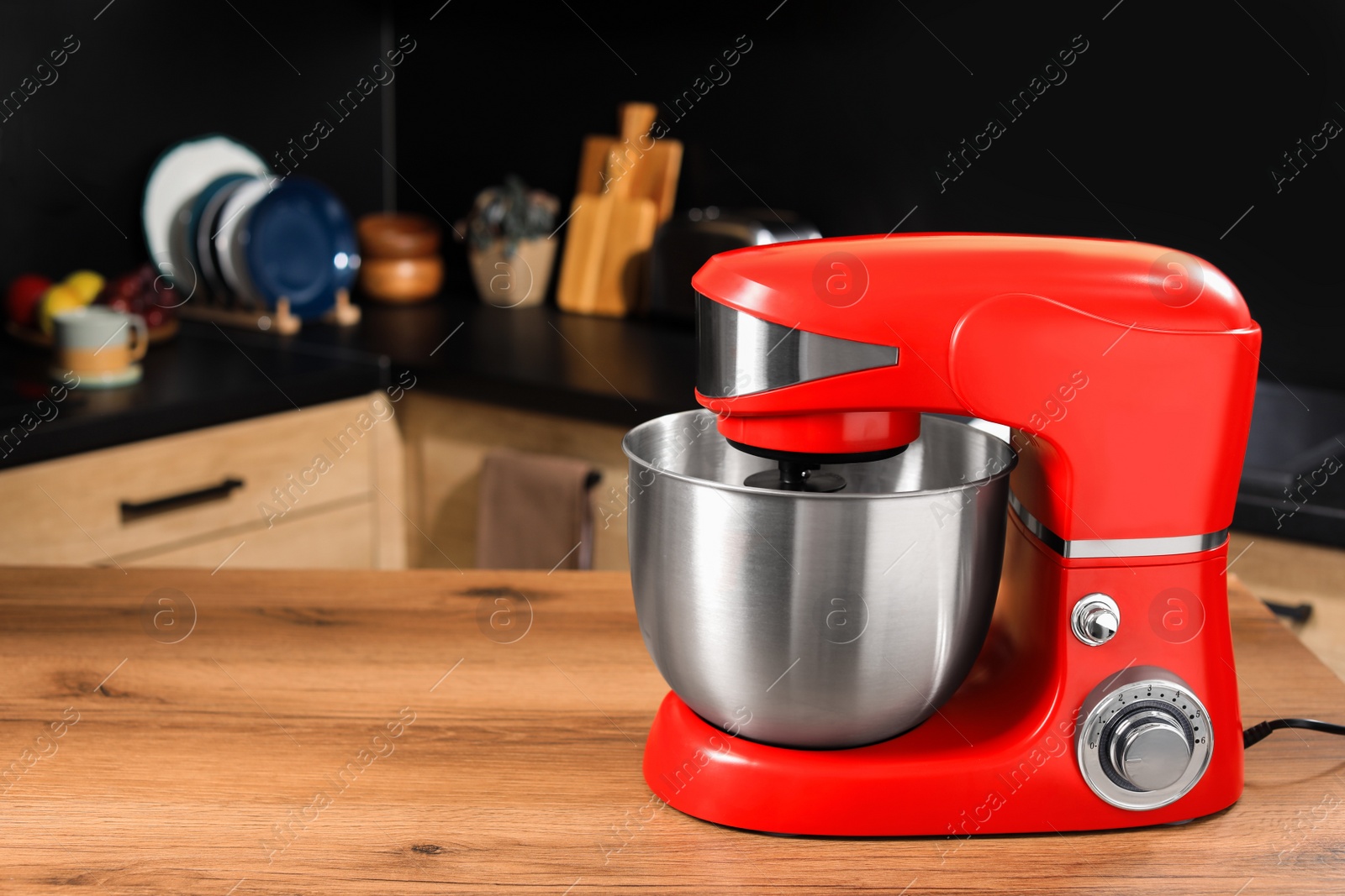 Photo of Modern red stand mixer on wooden table in kitchen