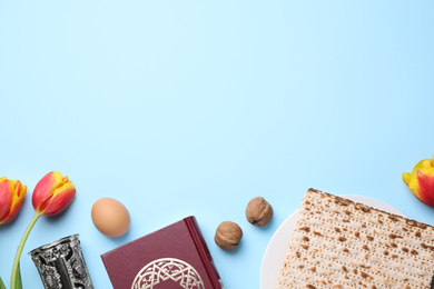 Photo of Flat lay composition with symbolic Pesach (Passover Seder) items on light blue background, space for text