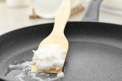 Frying pan with coconut oil on induction stove, closeup. Healthy cooking