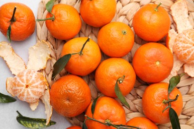 Photo of Many fresh ripe tangerines and leaves on light table, flat lay