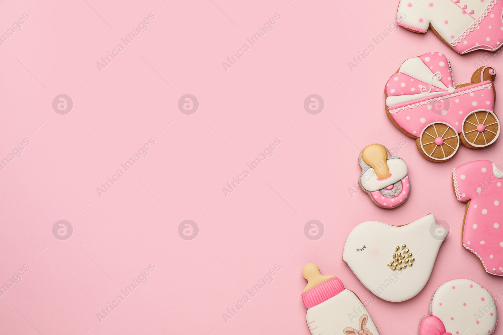 Photo of Cute tasty cookies of different shapes on pink background, flat lay with space for text. Baby shower party