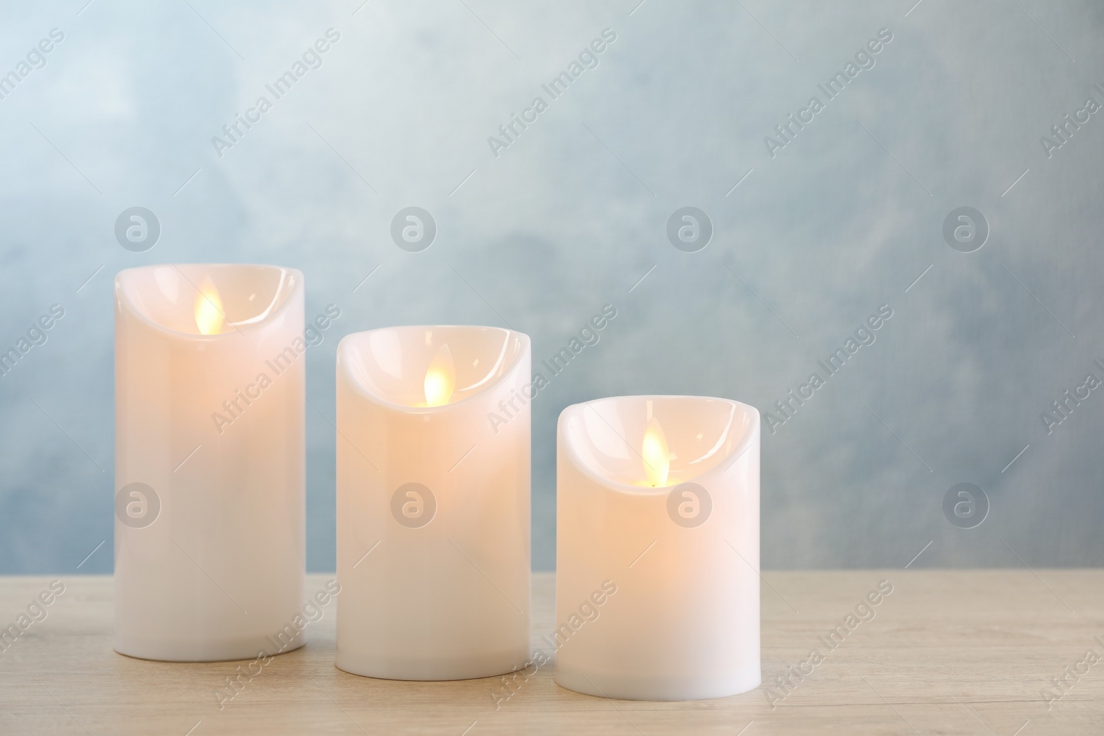 Photo of Decorative LED candles on light wooden table