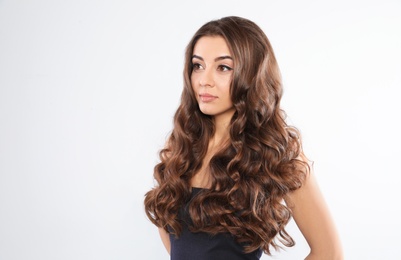 Beautiful woman with shiny wavy hair on white background