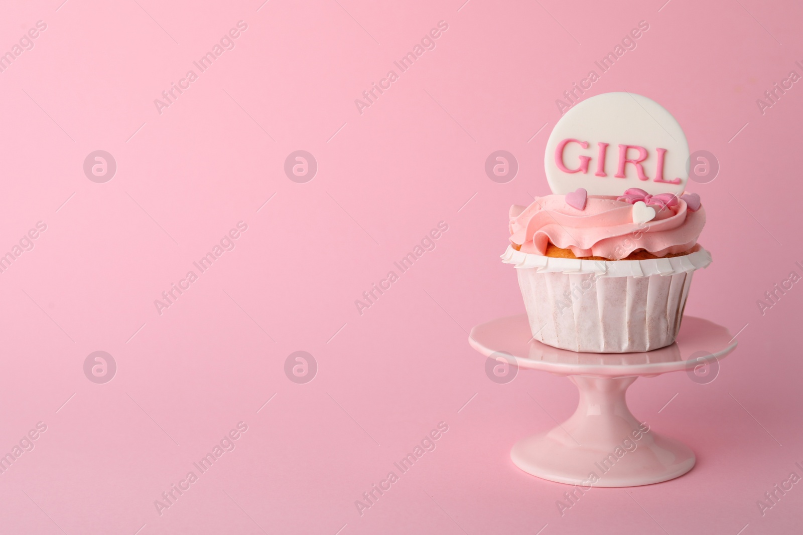 Photo of Baby shower cupcake with Girl topper on pink background, space for text