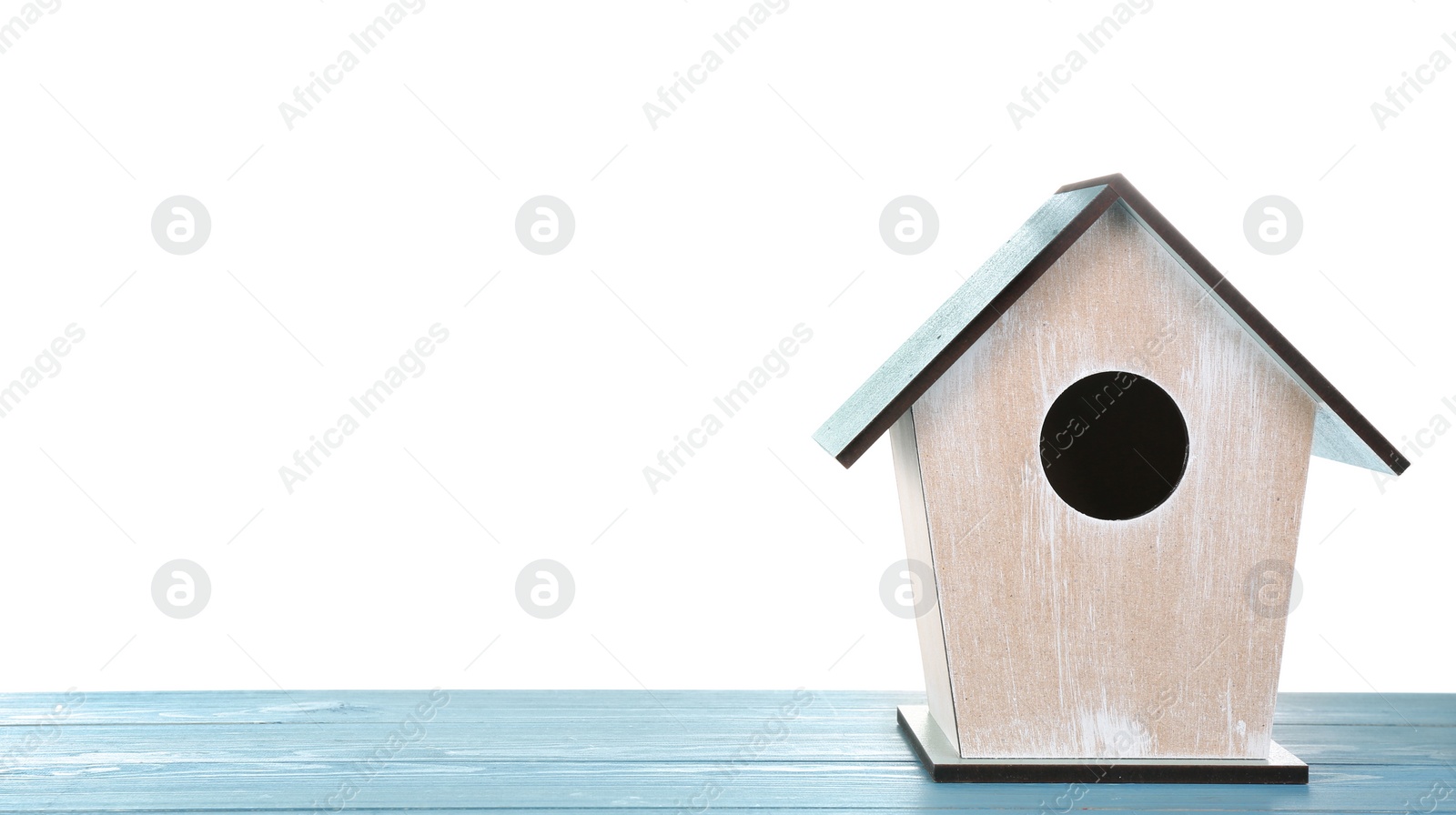 Photo of Beautiful bird house on light blue wooden table against white background, space for text