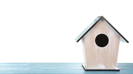 Photo of Beautiful bird house on light blue wooden table against white background, space for text